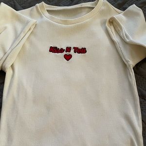 long white sleeve t shirt which says “Kiss N Tell”